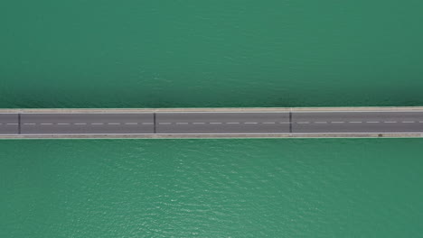 Vertikale-Aufnahme-Der-Brücke-Von-Oben-Mit-Vorbeifahrenden-Autos-Von-Links-Nach-Rechts,-Französischer-See